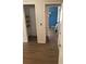 Hallway with views into a closet and a bedroom accented by wood look tile floors at 6403 Elliot Dr, Tampa, FL 33615