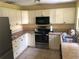 Bright kitchen featuring stainless steel appliances and countertops with tile backsplash at 6403 Elliot Dr, Tampa, FL 33615
