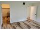 Large bedroom with new wood look floors; neutral paint; view to hot water heater at 6925-A Avenue Des Palais # 1A, South Pasadena, FL 33707