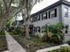 Exterior view of condo building with lush greenery and sidewalk at 6925-A Avenue Des Palais # 1A, South Pasadena, FL 33707