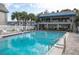 Beautiful pool area with a two-story clubhouse featuring a blue awning and comfortable seating at 6925-A Avenue Des Palais # 1A, South Pasadena, FL 33707