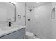 Bathroom featuring a sink vanity with modern fixtures and marble tiled shower at 7107 Limestone Ln, Tampa, FL 33619