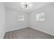Bedroom with wood-look floors, and two windows, and new light fixture at 7107 Limestone Ln, Tampa, FL 33619