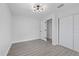 Bedroom with wood-look floors, closet, neutral walls and window, and new light fixture at 7107 Limestone Ln, Tampa, FL 33619