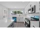 Bright kitchen featuring white cabinets, stone countertops, and modern appliances at 7107 Limestone Ln, Tampa, FL 33619