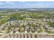 Aerial view of a lovely neighborhood with houses surrounding a serene lake with trees and green spaces at 7114 Bowspirit Pl, Apollo Beach, FL 33572
