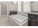 Soaking tub featuring granite countertops and tile surround, with door to toilet at 7114 Bowspirit Pl, Apollo Beach, FL 33572