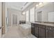 Relaxing bathroom featuring dual vanities, granite countertops, and a soaking tub at 7114 Bowspirit Pl, Apollo Beach, FL 33572