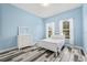 Bright blue bedroom with wood-style floor and a window at 7114 Bowspirit Pl, Apollo Beach, FL 33572