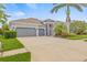 Attractive home features a three-car garage, tropical landscaping and an American flag at 7114 Bowspirit Pl, Apollo Beach, FL 33572