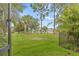 View of the manicured front yard with palm trees and a view of the home beyond the fence at 7114 Bowspirit Pl, Apollo Beach, FL 33572