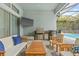 A screened in patio features outdoor furniture, an outdoor kitchen, and a flat screen television at 7114 Bowspirit Pl, Apollo Beach, FL 33572