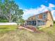 Beautiful backyard featuring a screened lanai, brick pathway, and tropical landscaping creating a serene outdoor environment at 7206 Timber Ct, Tampa, FL 33625