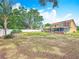 Large backyard showcasing a well-maintained lawn, mature trees, and a white fence, offering ample space for outdoor activities at 7206 Timber Ct, Tampa, FL 33625