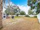 Expansive backyard featuring a white fence, palm trees, and sunroom attached to home at 7206 Timber Ct, Tampa, FL 33625