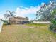 Spacious backyard view showcasing the home's sunroom, fenced yard and mature trees at 7206 Timber Ct, Tampa, FL 33625