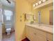 Well-lit bathroom with a large mirror, white vanity, and a view into the toilet and shower area at 7206 Timber Ct, Tampa, FL 33625