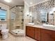 Modern bathroom featuring double sinks, granite countertops, and a spacious glass-enclosed shower at 7206 Timber Ct, Tampa, FL 33625