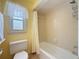 Well-lit bathroom featuring a shower-tub combo, and a frosted window at 7206 Timber Ct, Tampa, FL 33625