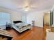 Sunlit bedroom featuring hardwood floors, white trim, a ceiling fan, and updated window trim at 7206 Timber Ct, Tampa, FL 33625