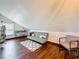 Attic bedroom featuring hardwood floors, neutral walls, and a cozy seating area at 7206 Timber Ct, Tampa, FL 33625