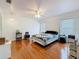 Sunlit bedroom featuring hardwood floors, white trim, a ceiling fan, and updated window trim at 7206 Timber Ct, Tampa, FL 33625