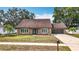 Charming single-story home with a well-maintained front yard, double door entry, and attached garage at 7206 Timber Ct, Tampa, FL 33625