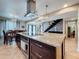 Modern kitchen with stainless steel range hood, granite island, pendant lights, and floating staircase in background at 7206 Timber Ct, Tampa, FL 33625