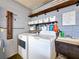 Functional laundry room with washer, dryer, sink, and open shelving, enhancing home convenience at 7206 Timber Ct, Tampa, FL 33625