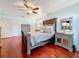 Bright main bedroom with wood floors, a ceiling fan and a large bed with stylish furniture at 7206 Timber Ct, Tampa, FL 33625