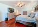 Spacious main bedroom with wood floors, a large TV and stylish furniture at 7206 Timber Ct, Tampa, FL 33625