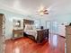 Bright main bedroom with wood floors, a ceiling fan and a large bed with stylish furniture at 7206 Timber Ct, Tampa, FL 33625