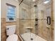 Modern shower featuring glass doors, tiled walls, and a built-in bench at 7206 Timber Ct, Tampa, FL 33625