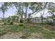 View of the backyard with mature trees and grass at 7625 Marechal Ave, Port Richey, FL 34668