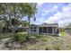 The backyard features a spacious lawn, updated paint, a screened-in porch, and new fencing at 7625 Marechal Ave, Port Richey, FL 34668
