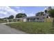 Quaint single-story home featuring a manicured lawn, gray exterior, and an attached garage at 7625 Marechal Ave, Port Richey, FL 34668