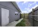 A fenced-in yard, access door, and manicured lawn surround this gray single-story home at 7625 Marechal Ave, Port Richey, FL 34668