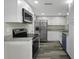 Updated kitchen with stainless steel appliances, granite countertops, and white cabinetry at 7625 Marechal Ave, Port Richey, FL 34668