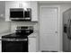 Updated kitchen showing stainless steel microwave, range, and granite countertops at 7625 Marechal Ave, Port Richey, FL 34668