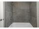 The shower has gray tiling and glass shelves at 7625 Marechal Ave, Port Richey, FL 34668