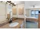 Bathroom featuring a vanity with granite countertop, decorative mirror, and view into the main bedroom at 7892 Sailboat Key S Blvd # 408, South Pasadena, FL 33707