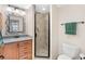 Bathroom featuring a stand up shower, light wood vanity, and decorative mirror at 7892 Sailboat Key S Blvd # 408, South Pasadena, FL 33707