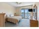 Bright bedroom features neutral decor, plush carpet, balcony access, and waterfront view at 7892 Sailboat Key S Blvd # 408, South Pasadena, FL 33707