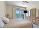Bedroom features neutral tones, ceiling fan, slider to balcony with water views, and dresser with matching mirror at 7892 Sailboat Key S Blvd # 408, South Pasadena, FL 33707