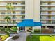 Building entrance with covered access, detailed signage, manicured bushes and mature palms at 7892 Sailboat Key S Blvd # 408, South Pasadena, FL 33707