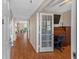 Foyer featuring wood floors, an open view to the living area, and a den with built-ins at 7892 Sailboat Key S Blvd # 408, South Pasadena, FL 33707