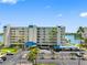 Property with a parking lot, covered parking, and lush landscaping with beautiful palm trees at 7892 Sailboat Key S Blvd # 408, South Pasadena, FL 33707