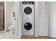 In-unit laundry featuring a stackable washer and dryer, toilet, and white bi-fold doors at 7892 Sailboat Key S Blvd # 408, South Pasadena, FL 33707