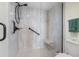 Stand-up shower with glass door, matte black hardware, white tiled walls, grab bar, and built-in bench at 7892 Sailboat Key S Blvd # 408, South Pasadena, FL 33707