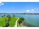 Scenic waterfront view showcasing a walking path, palm trees, and blue skies at 7892 Sailboat Key S Blvd # 408, South Pasadena, FL 33707